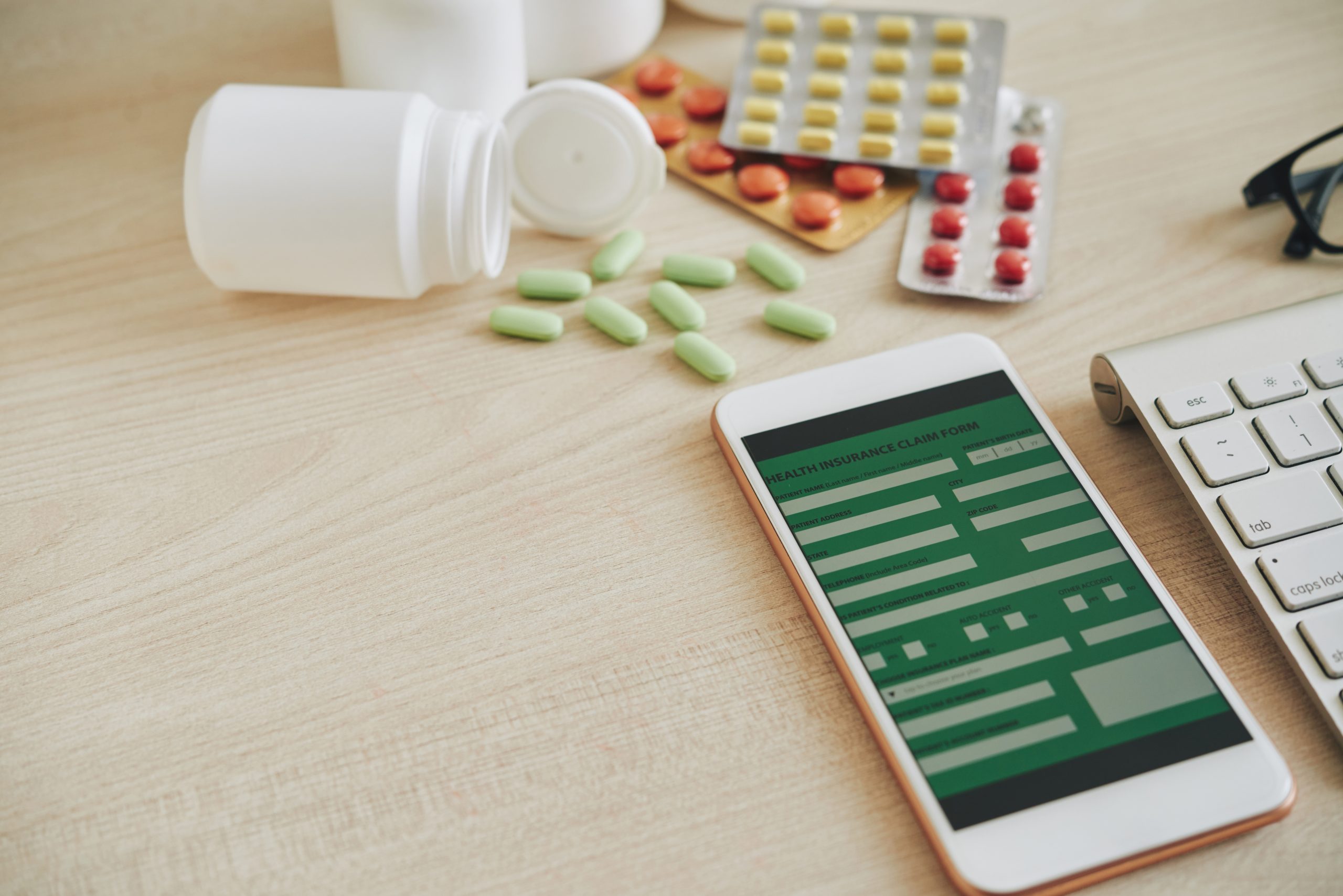 Smartphone with heath insurance application and tablets on table